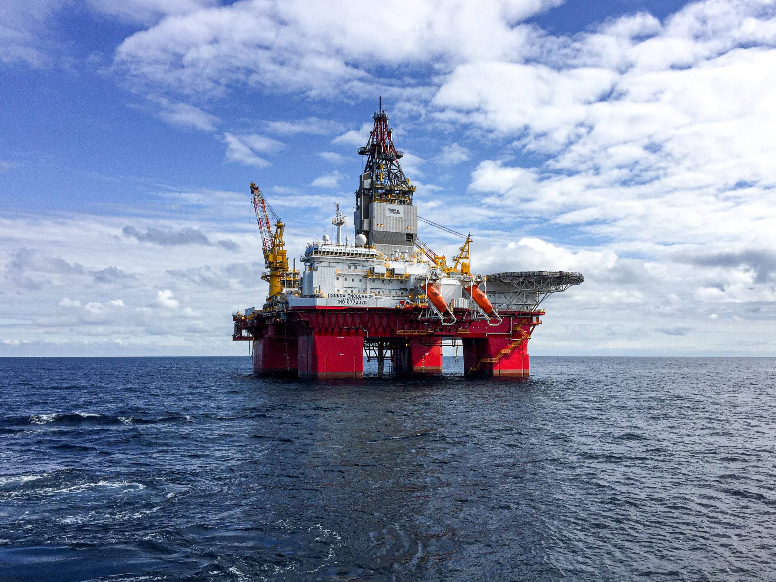 red oil rig on ocean
